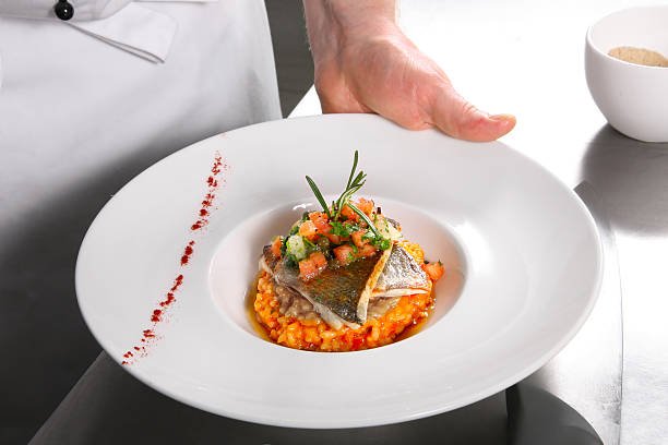 Chef demonstrating prepared risotto with, fish