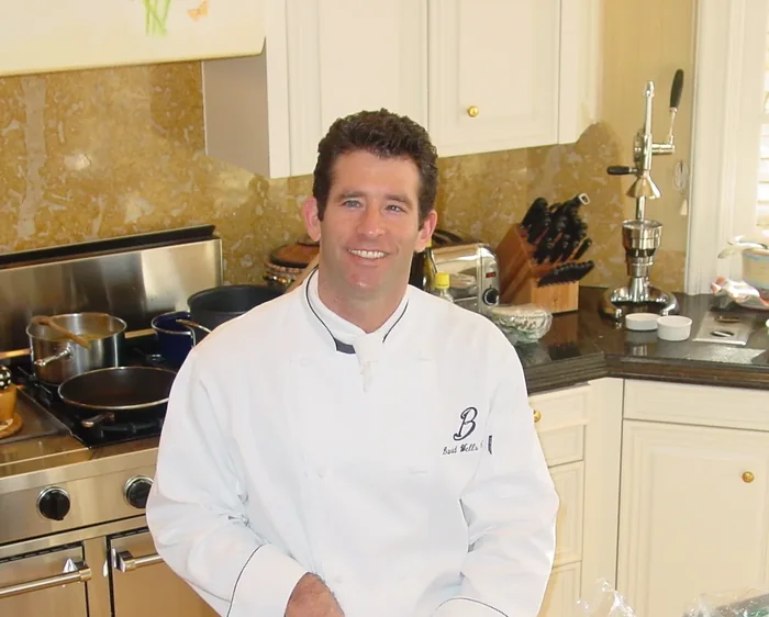 Private chef prepping vegetables on a cutting board in a home kitchen